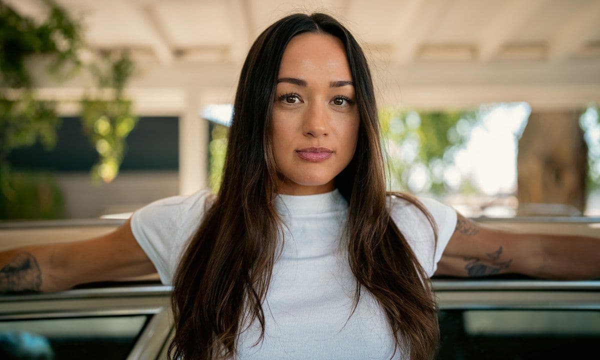 A portrait of a woman in a white shirt, sunlit